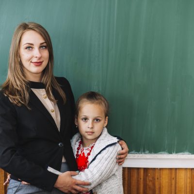 female-teacher-with-student-girl-standing-cuddling